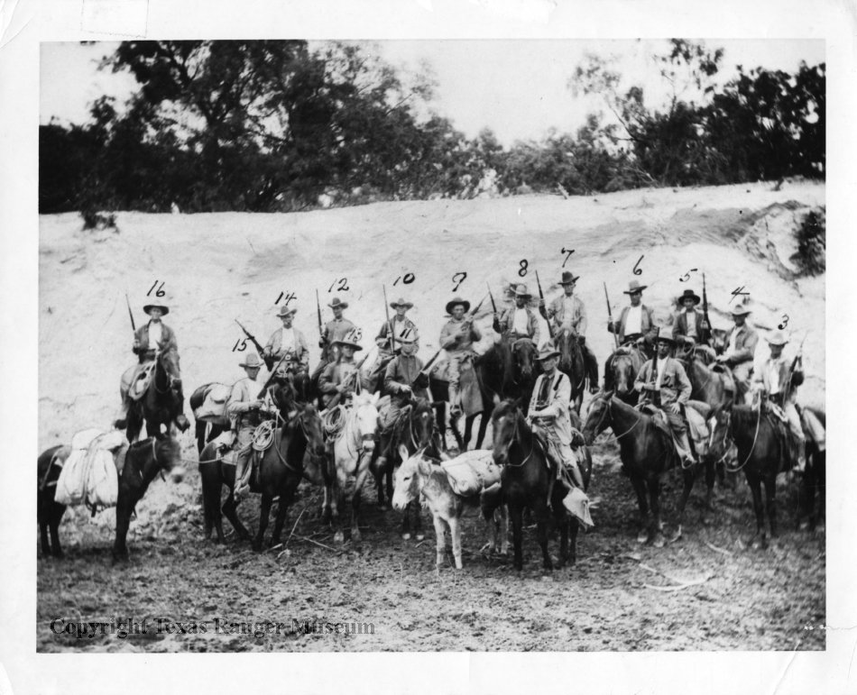 Black and white photo of a group of white men on horseback all wearing wide-brimmed hats and carrying rifles.